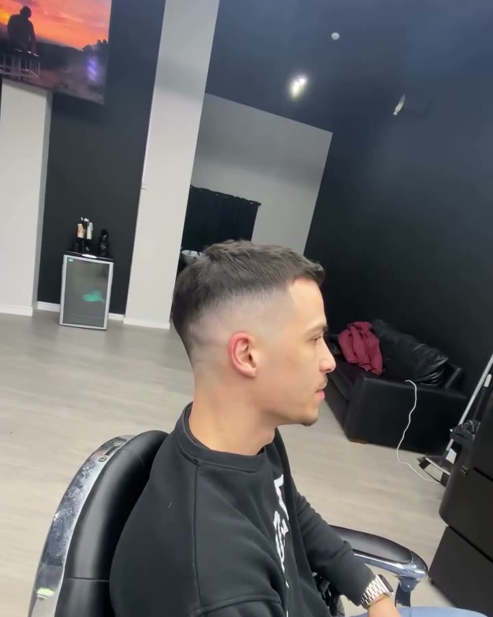 Skin fade alto, de perfil, na cadeira