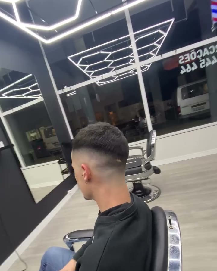 O interior da barbearia com o teto de luzes hexagonais